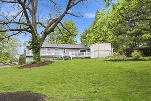 A residential property with a large lawn, a house with a porch, and a fenced garden area. - Mason Ranch - Game Room w/ Hot tub (Mason)