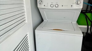Et lille vaskerum med vaskemaskine og tørretumbler stablet oven på hinanden.