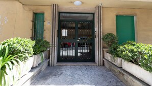 A building entrance with a green door, numbered 85, and potted plants on either side. - GuestHost - Bright Apartment near Vatican City (Rome)