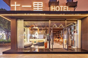 Entrada de hotel com design moderno, área de recepção e assentos visíveis no interior.