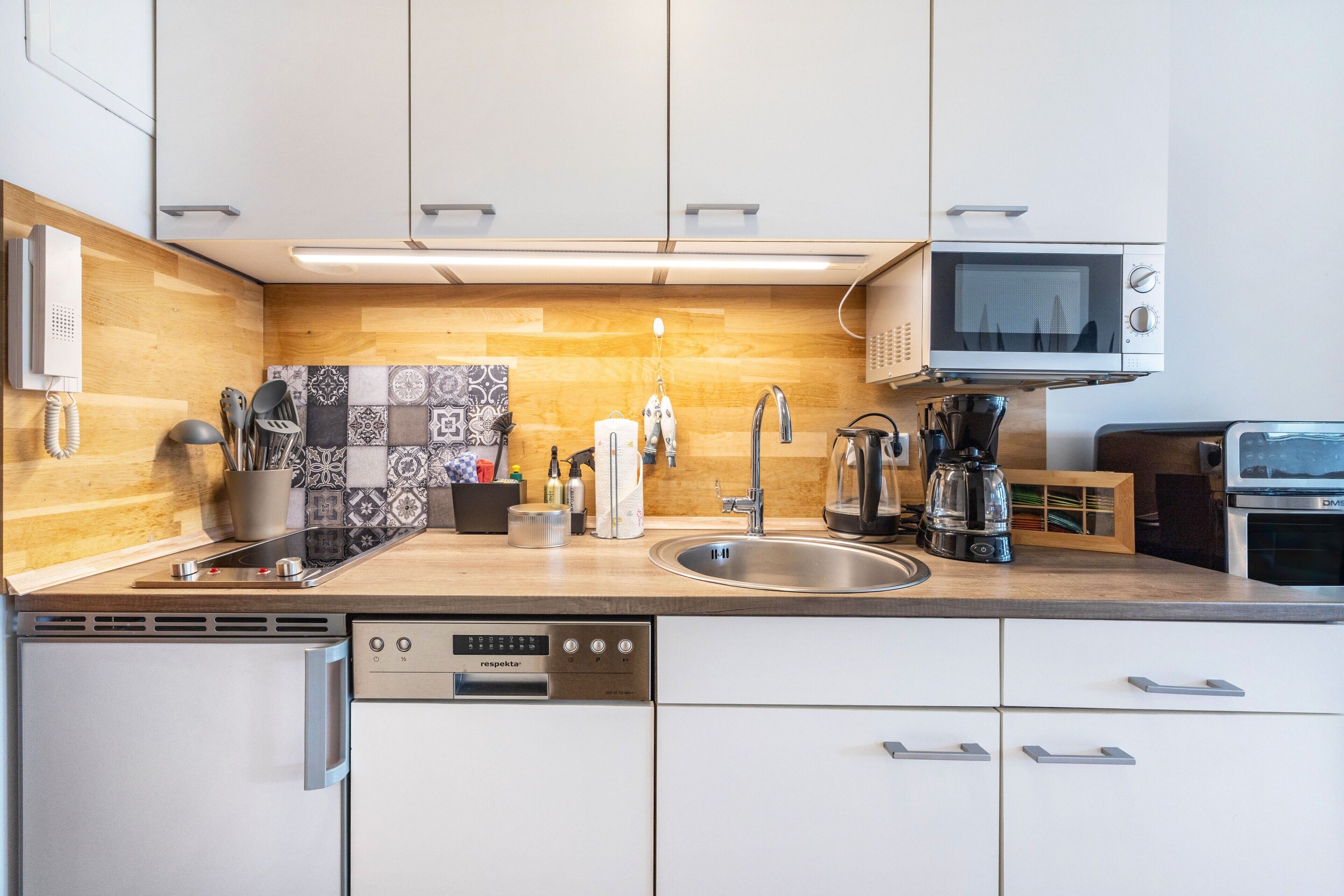 A modern kitchen with a dishwasher, microwave, and coffee maker.