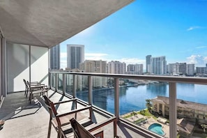 A balcony with a view of a city skyline and a body of water. - Resort 1BR · Sunset View · Beach Shuttle (Hallandale Beach)