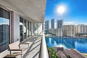 Uma varanda com vista para um porto de iates e edifícios altos.