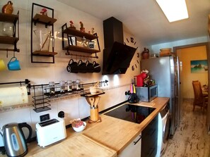 Een keuken met een broodrooster, waterkoker en een houten aanrecht.