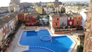 Un quartier résidentiel avec des bâtiments aux couleurs vives, une piscine et une vue sur le paysage urbain.