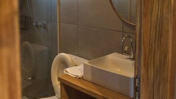 A bathroom with a shower, toilet, and sink.