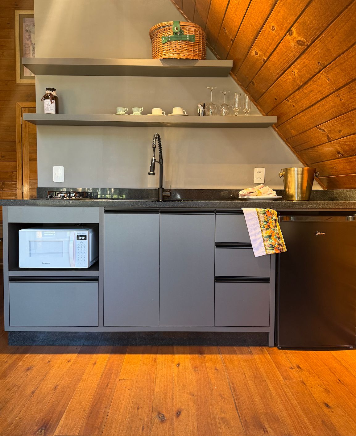 Una cocina con microondas, pileta y alacenas.