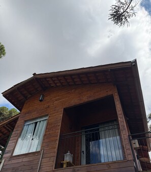Un edificio de madera con balcón y ventana.