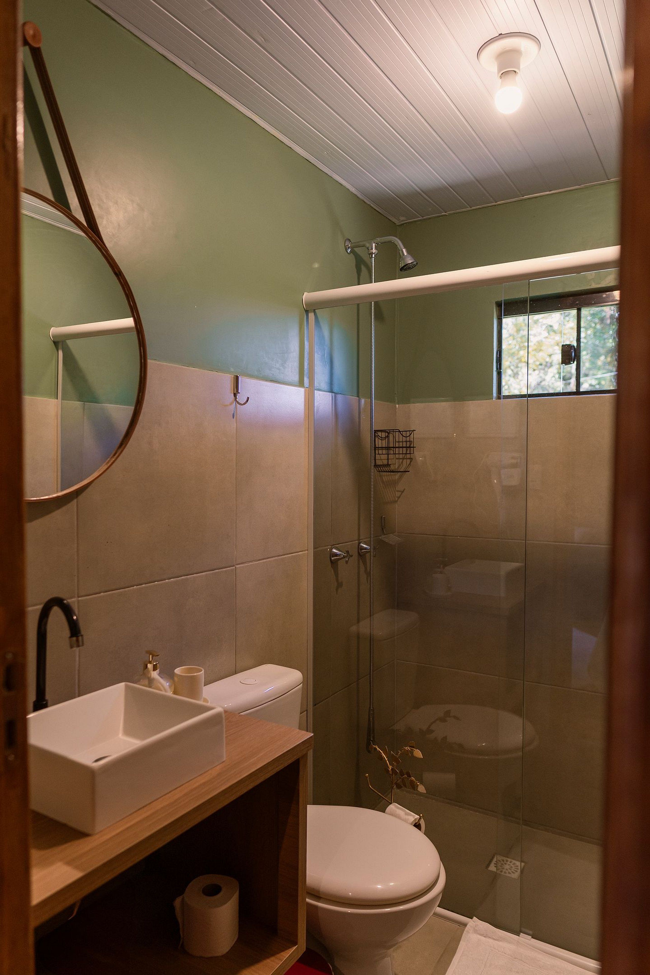 A bathroom with a sink, toilet, and glass-enclosed shower.