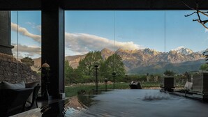 A hot tub with a mountain view, stone walls, and outdoor seating. - Tangting Hidden Hotel (Lijiang)