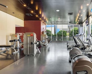 A gym with cardio machines, weight equipment, and large windows offering a view of the outdoors. - Stylish 1BR, Bay View Balcony, Resort & Beach (Hallandale Beach)