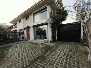A two-story house with a large garage, a front porch, and a paved driveway.