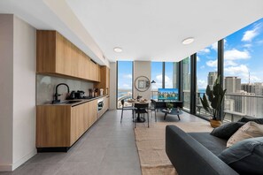 A modern apartment with a kitchen, dining area, and a balcony with a city view. - Miami Worldcenter | Luxury 2BR & Rooftop Pool (Miami)