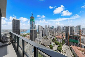 Une vue urbaine avec de hauts immeubles, une grue de construction et un ciel bleu dégagé.
