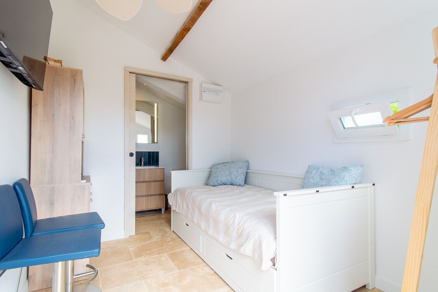 Une chambre à coucher avec un lit, un bureau et un miroir.