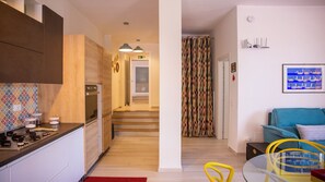 A modern kitchen with wooden cabinets, a stove, and a countertop with kitchenware. - Solemar Sicilia - Casa Zagara (Santa Flavia)