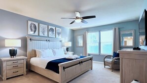 A bedroom with a bed, nightstands, a ceiling fan, artwork, and a window with blinds. - South-Facing Pool & Spa • Lazy River & Waterslides • Gated Resort • Near Disney (Davenport)