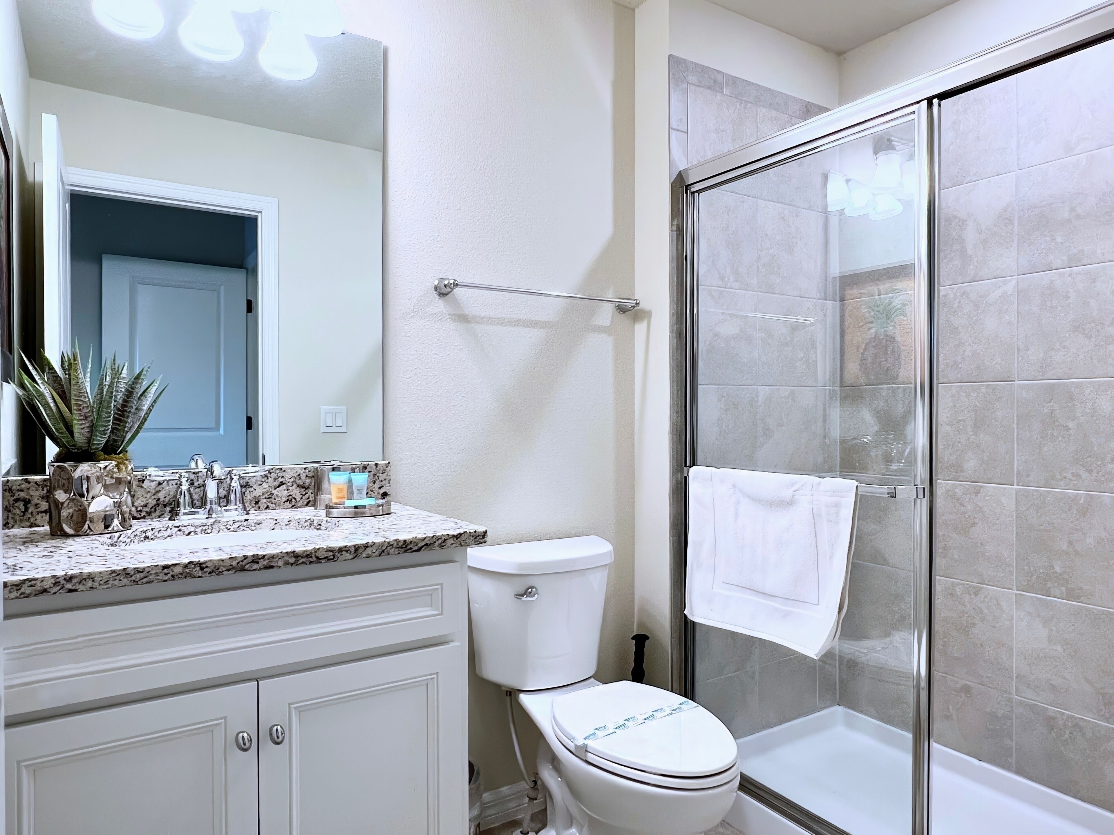 A bathroom with a shower, toilet, and sink.