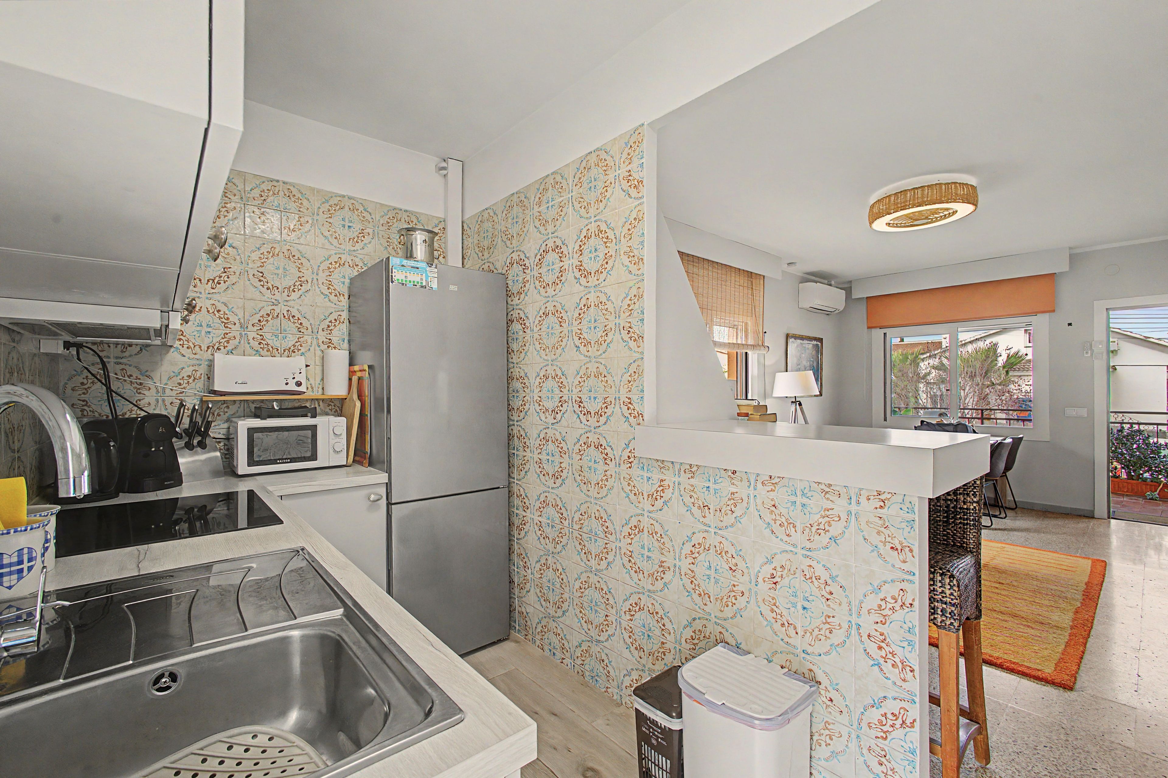 A compact kitchen with a refrigerator, microwave, and stove.