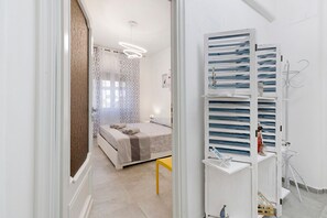 A bedroom with a bed, bedside table, and a wardrobe with shelves.