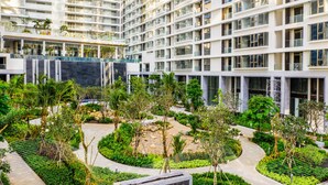A modern hotel with multiple floors, a central courtyard with greenery, and a pool area. - Là Home - Stay Cozy, Stay Home Phú Mỹ Hưng (Ho Chi Minh City)