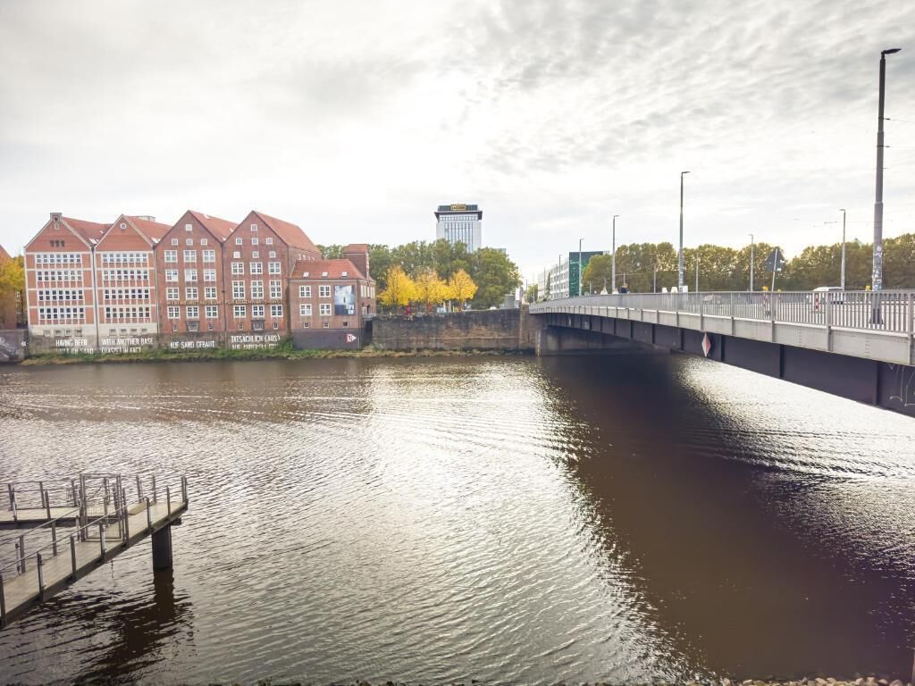 A river with a bridge, buildings, and a dock.