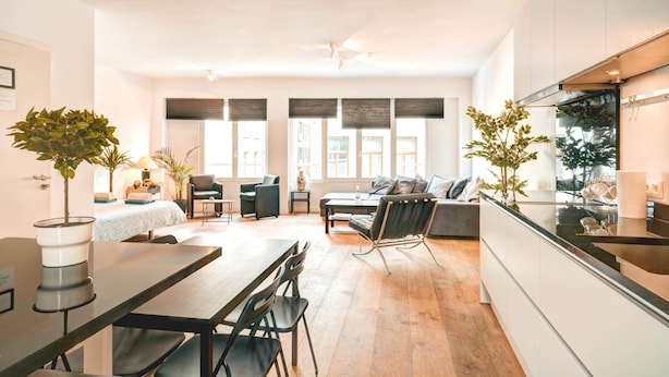 Eine moderne Küche mit Essbereich, einer Couch und einem kleinen Tisch mit Stühlen.