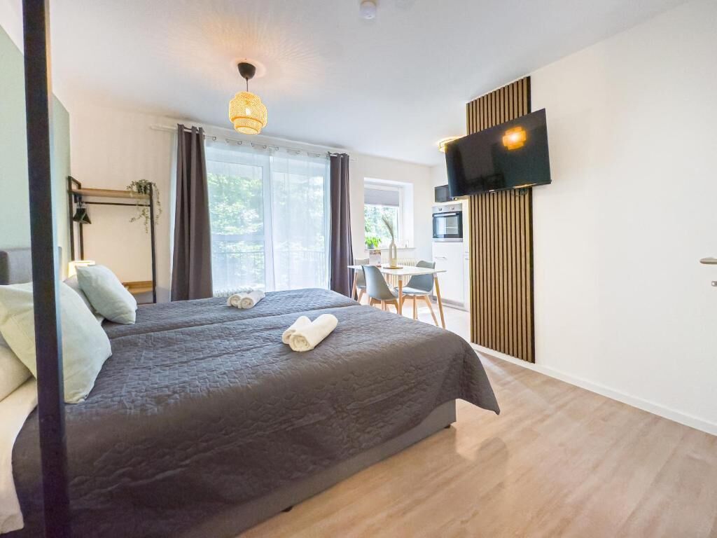 Una habitación de hotel con cama, televisión, escritorio y silla.