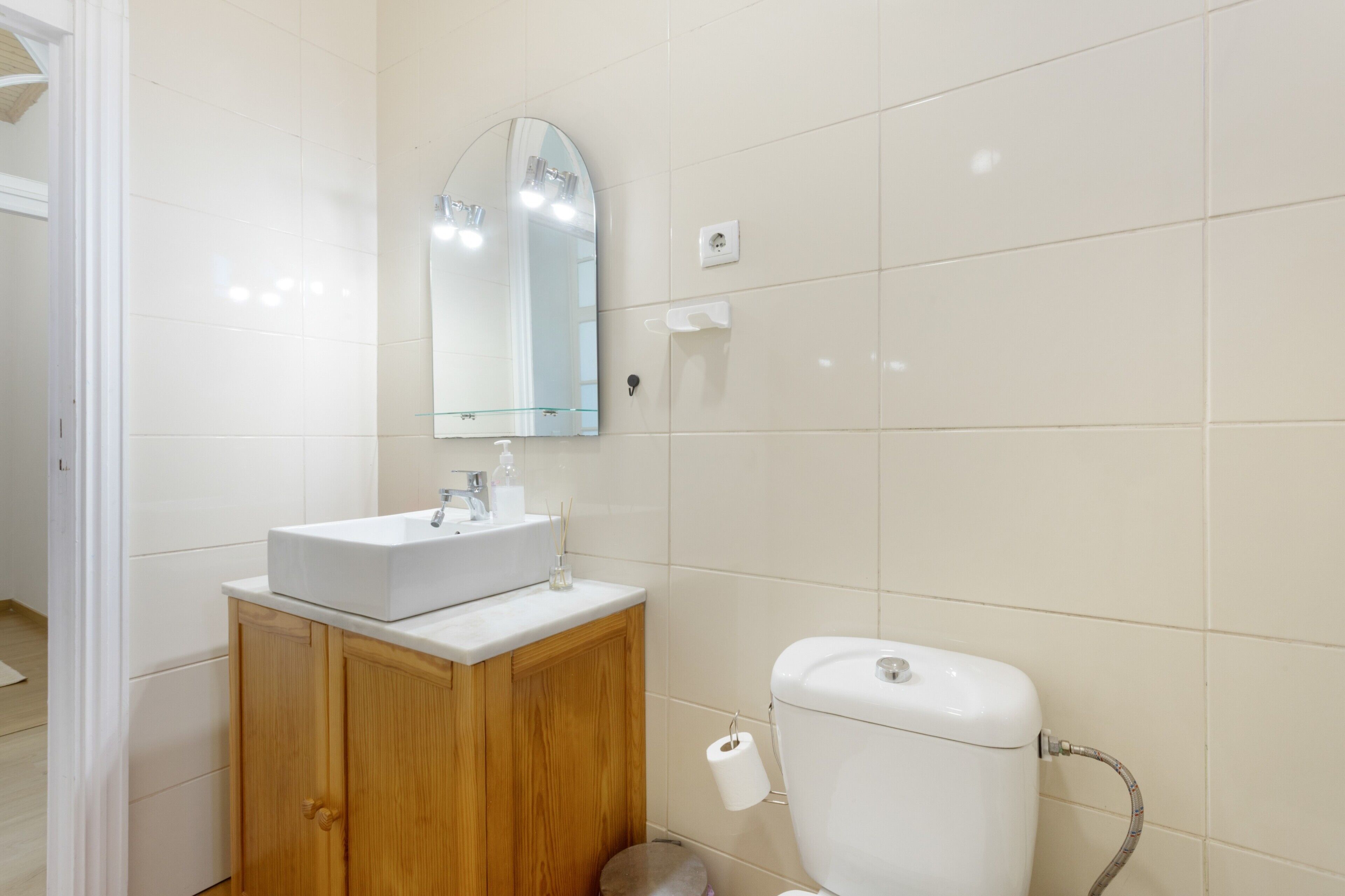 Ein Badezimmer mit Waschbecken, Holzkabinent und Toilette.