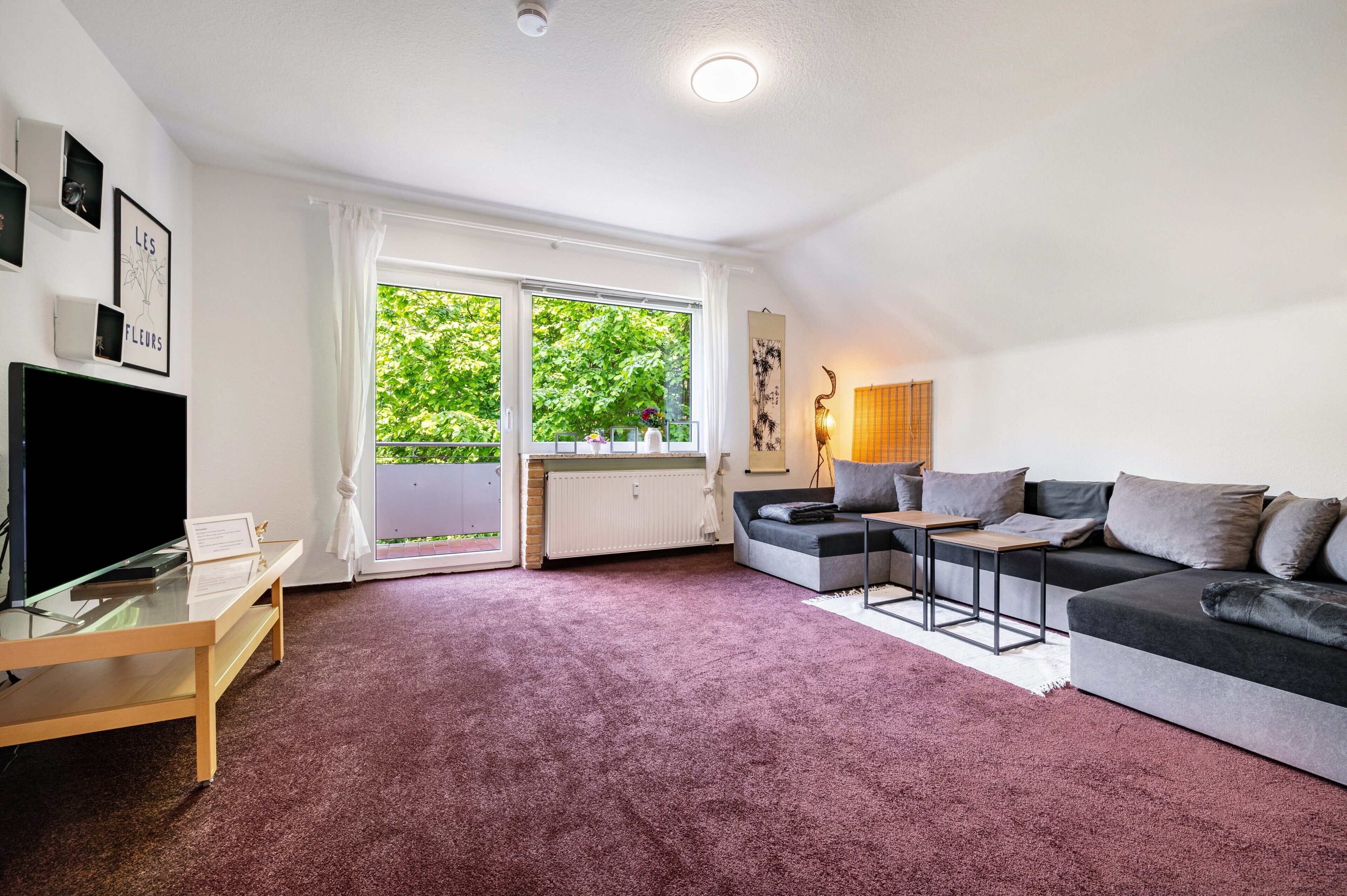 Een moderne woonkamer met een bank, een salontafel en een televisie op een meubel.
