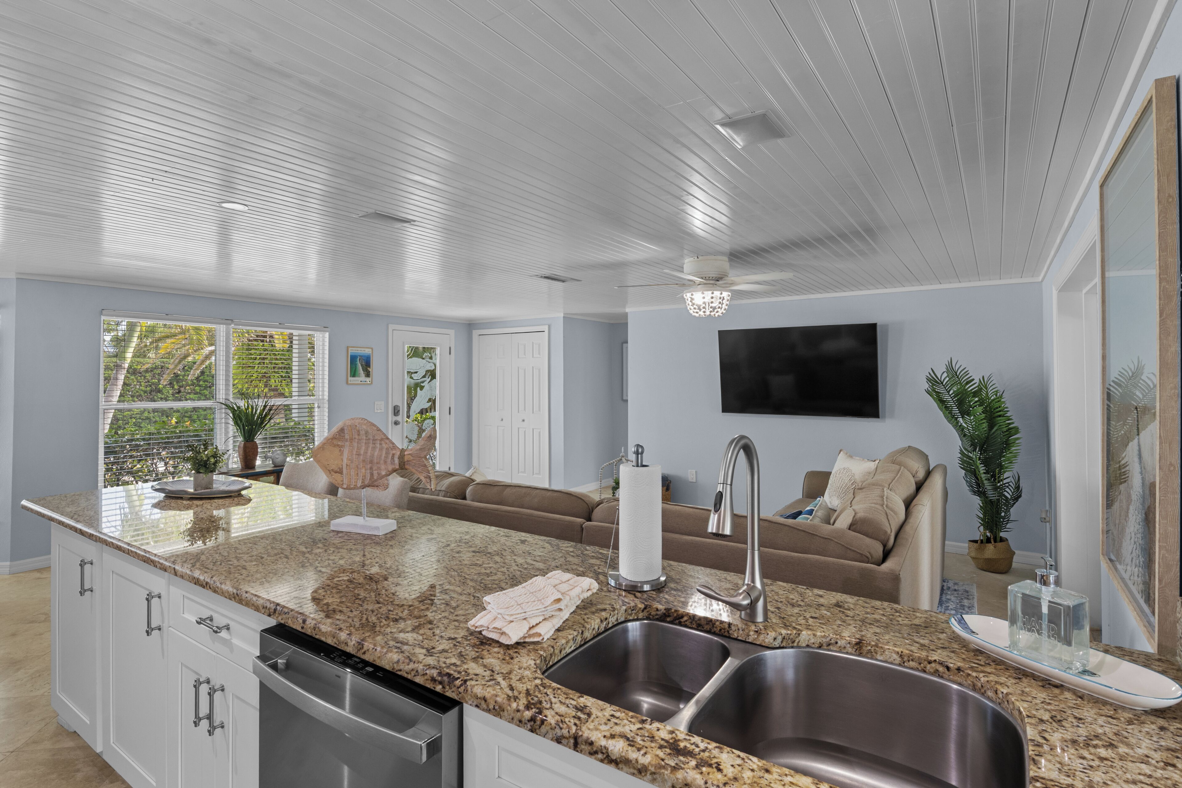 A modern kitchen with granite countertops, stainless steel sinks, and a built-in dishwasher.