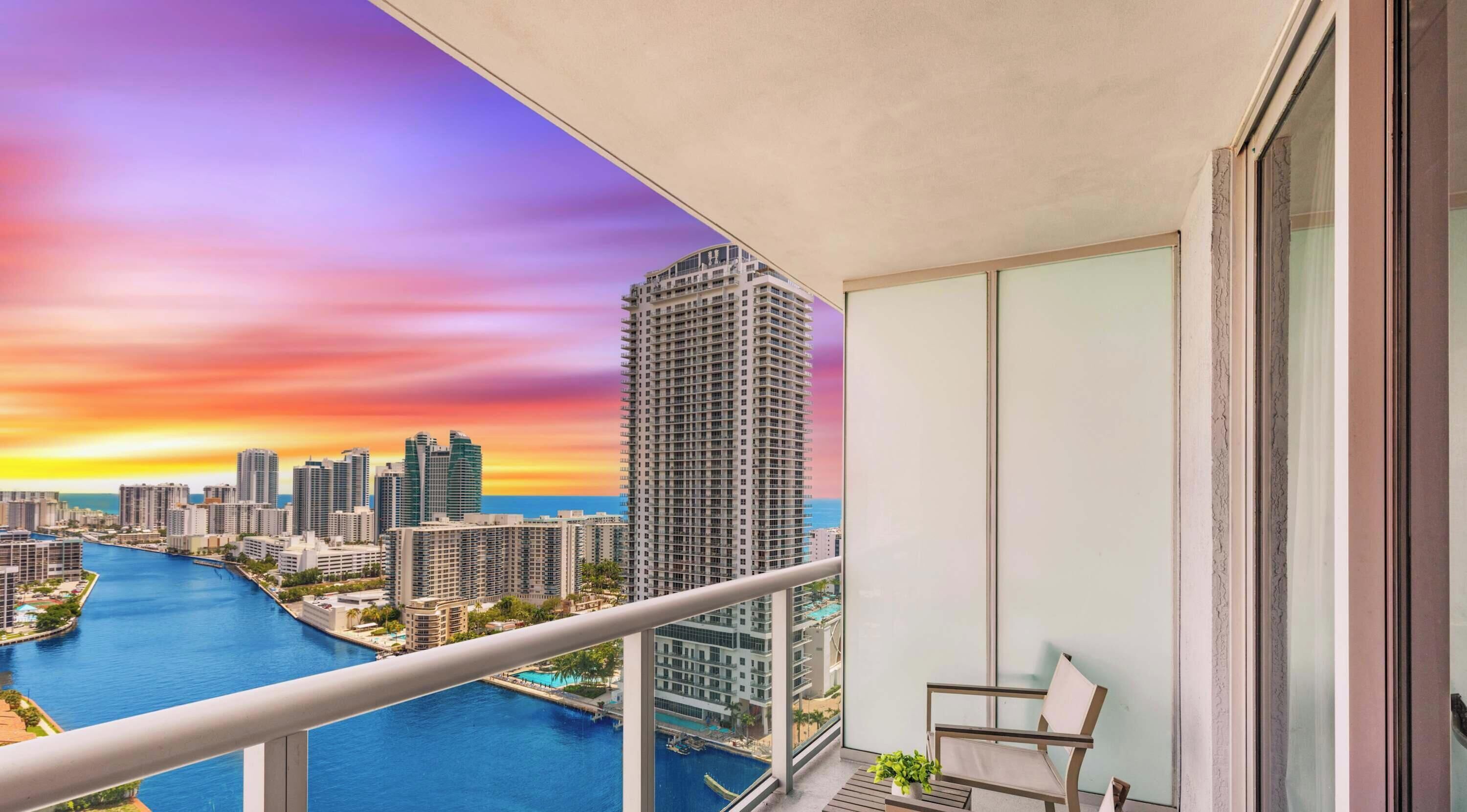 A balcony with a city view, a pool, and a chair.