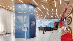 A modern lobby with a reception desk, a blue information kiosk, and a world map on the wall. - High-Floor Studio | Intracoastal, Sleeps 4 (Hallandale Beach)