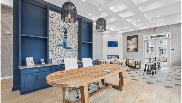 Eine moderne Hotelhalle mit einem großen Holztisch, blauen Schränken und einer Wand aus Mosaiksteinen.