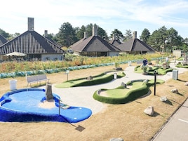 Un jardín ajardinado con piscina, bancos y un sendero.