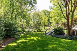 Un jardin bien entretenu, avec un escalier en bois menant à un bâtiment.