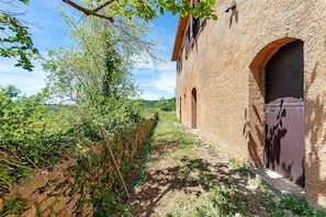 A rustic building with arched windows and a stone wall.