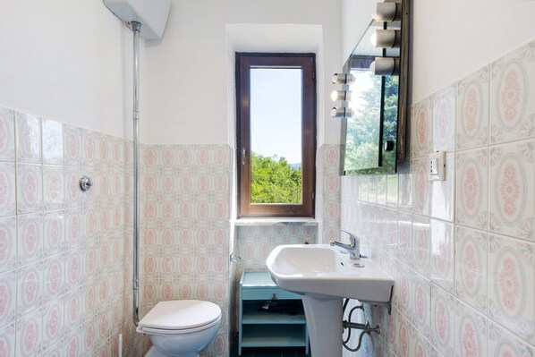 A bathroom with a toilet, sink, and window. - Country House 'Le Vallocchie' with Mountain View and Private Garden (Concerviano)