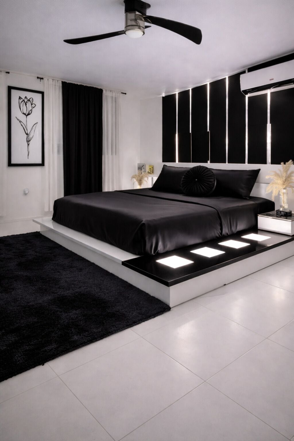 Une chambre moderne avec un lit, des tables de chevet, un ventilateur de plafond et un climatiseur fixé au mur.