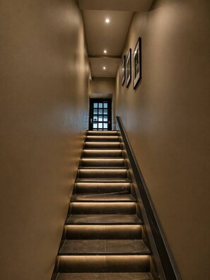 A staircase with a handrail, leading to a door with a glass panel. - Boutique Old Montreal Suite-1C (Montreal)