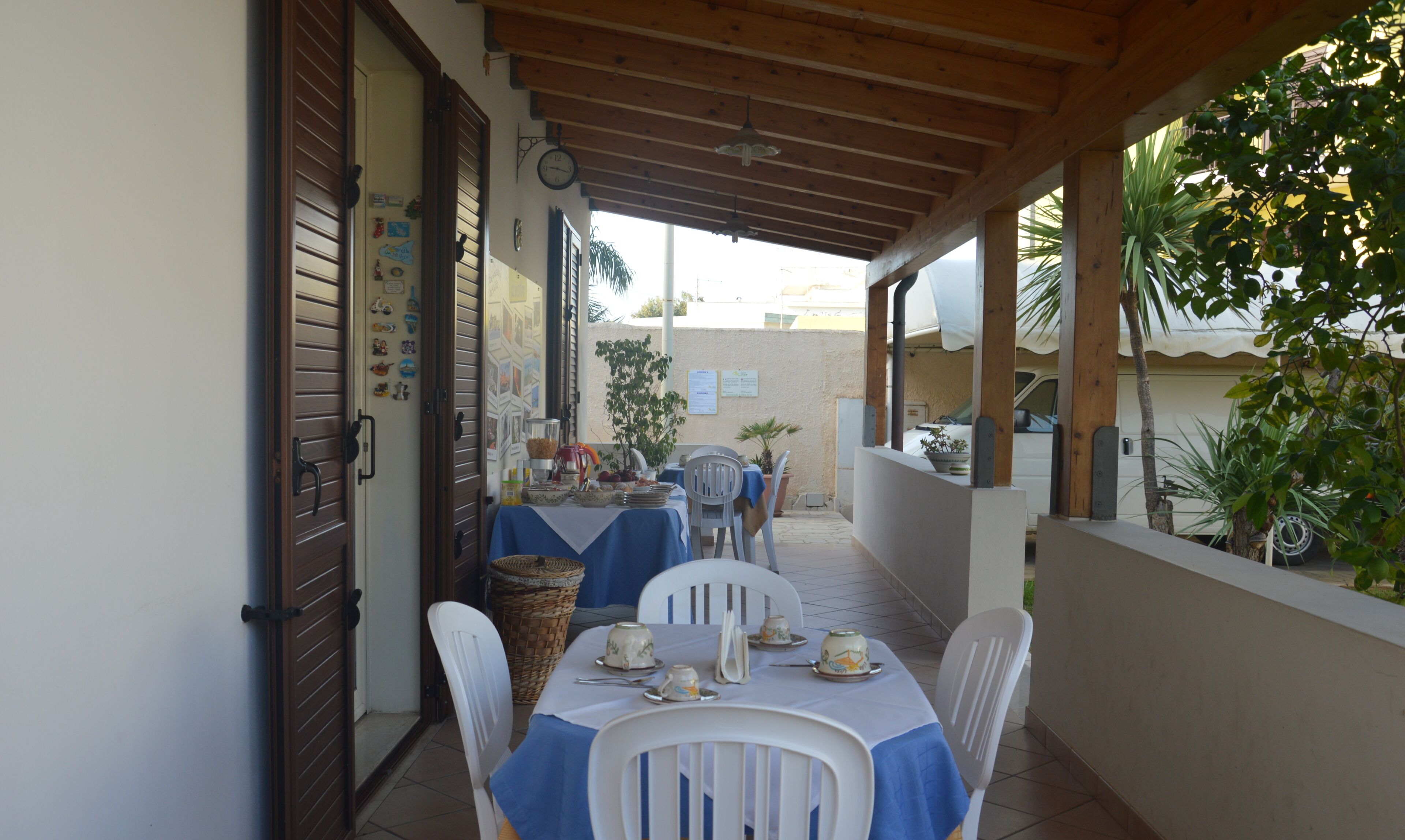 Un área de comedor al aire libre techada, con una mesa para dos, sillas y una cesta.