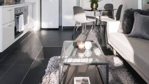 Una sala moderna con sofá, mesa de centro y comedor.