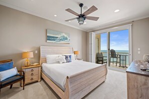 A bedroom with a bed, nightstand, lamp, and a view of the ocean through a sliding door. - Avalon Penthouse 4 - Top of the Tower Luxury! Beach Club - 5/5 Double Mstr (Gulf Shores)