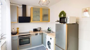 Eine kompakte Küche mit Geschirrspüler, Backofen, Mikrowelle und integriertem Waschmaschine.