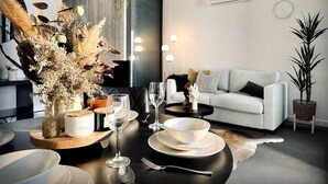 Un salon moderne comprenant un coin repas, un canapé, une table basse et une plante en pot.
