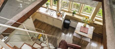 A spacious loft-style room with a glass ceiling, a dining area, and a cozy seating area.