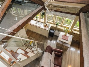 A spacious loft-style room with a glass ceiling, a dining area, and a cozy seating area. - Riverview Cottage (Holmfirth)
