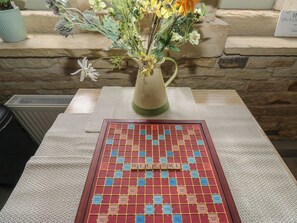 Ein Scrabble-Spielbrett mit dem Wort 'WELCOME', platziert auf einer strukturierten Tischdecke.