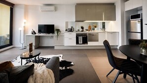 A modern kitchen with white cabinets, a built-in oven, and a microwave. - Central Melbourne Skyline Retreat (Melbourne)