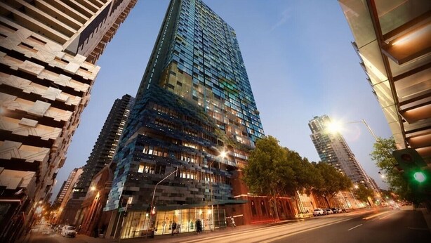 A modern high-rise building with a glass facade, surrounded by other tall buildings. - Central Melbourne Skyline Retreat (Melbourne)